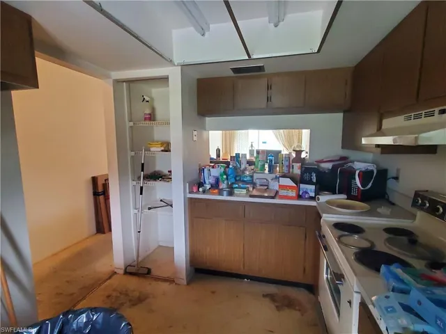 Kitchen featuring electric stove and wall chimney range hood