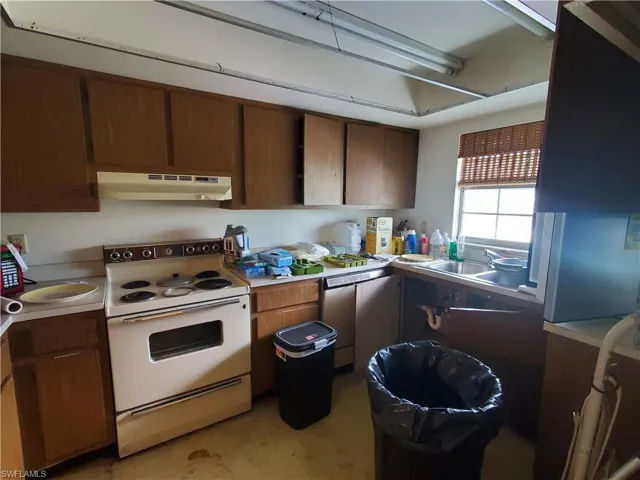 Kitchen with sink, stainless steel dishwasher, and white electric stove
