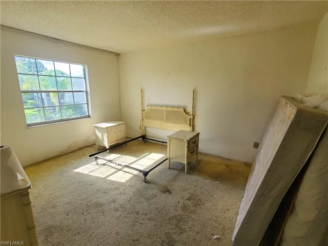 Carpeted bedroom featuring a textured ceiling