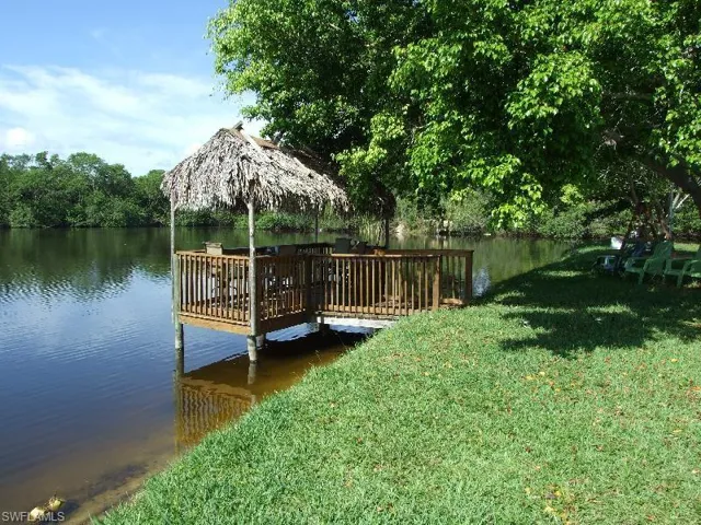 Dock area featuring a water view and a lawn