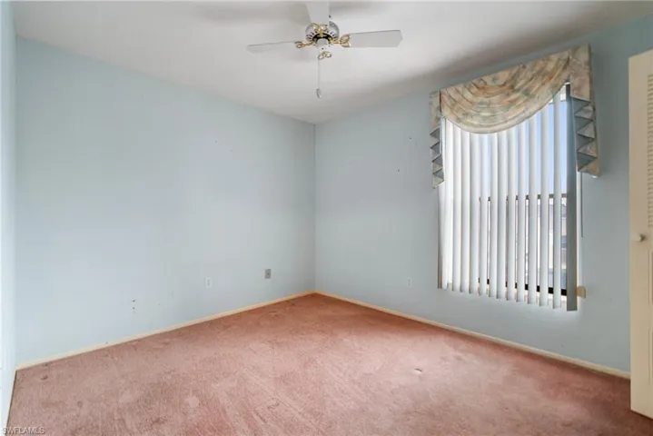 Empty room featuring carpet flooring and ceiling fan