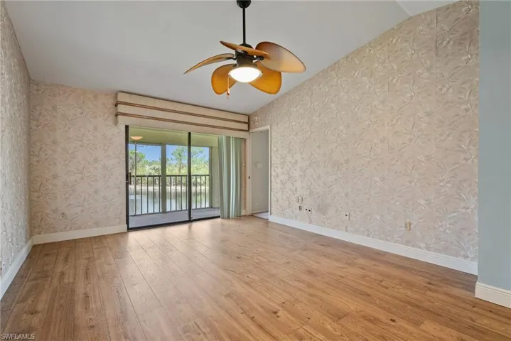 Spare room with ceiling fan, a water view, light hardwood / wood-style flooring, and lofted ceiling
