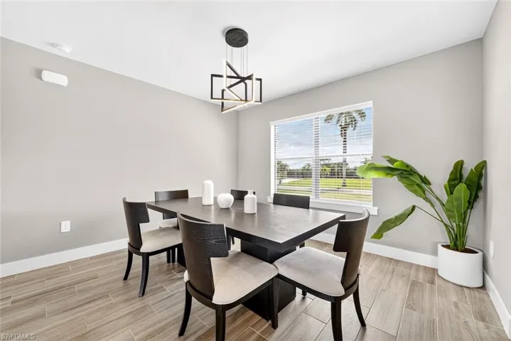 Dining area with wood tiled floors and a chandelier