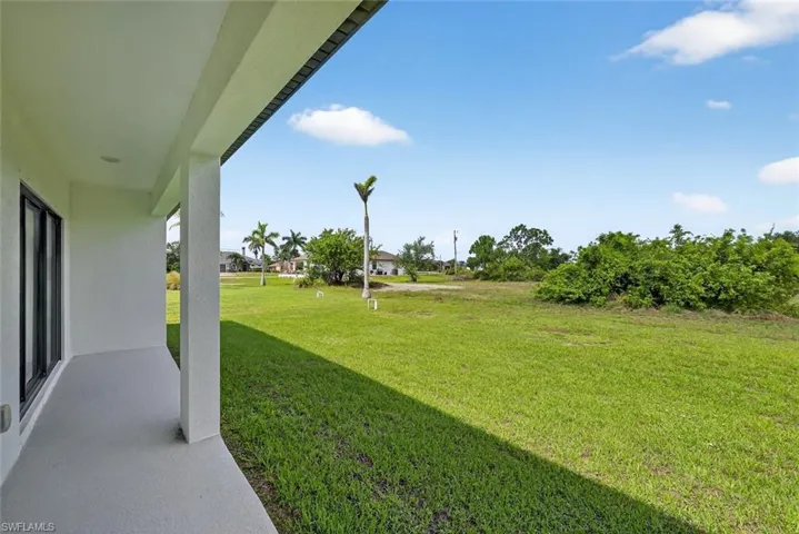 View of green lawn with a patio area