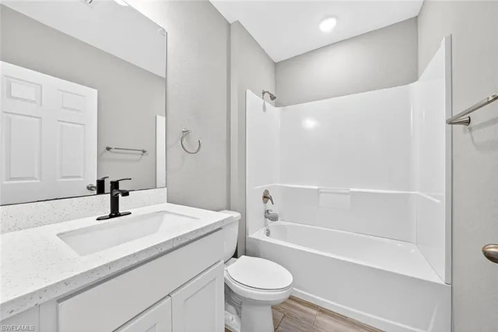 Full bathroom featuring bathtub / shower combination, vanity, and wood finish floors