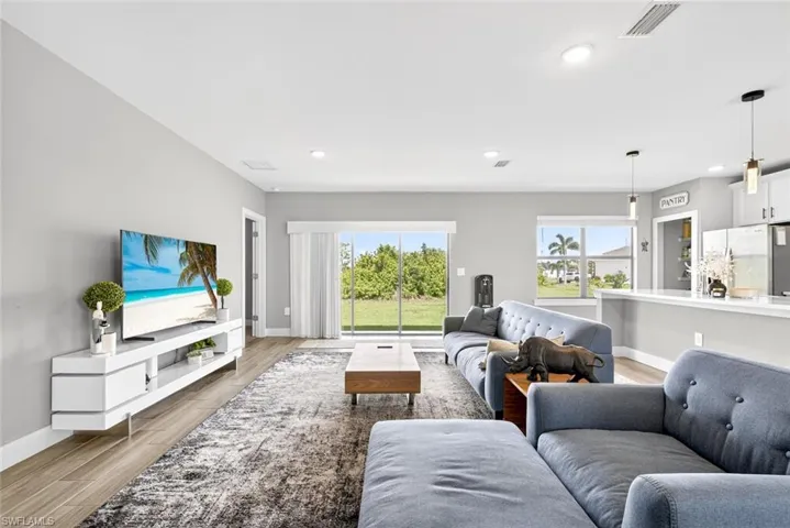 Living room with light wood-style floors and recessed lighting
