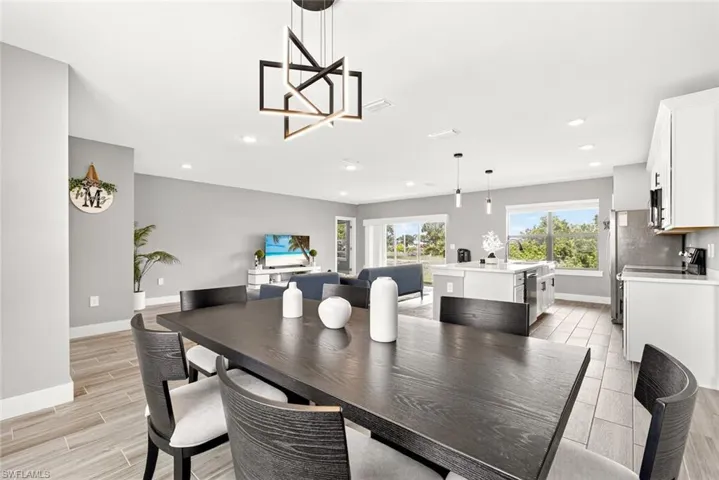 Dining space with wood finish floors, recessed lighting, and a chandelier