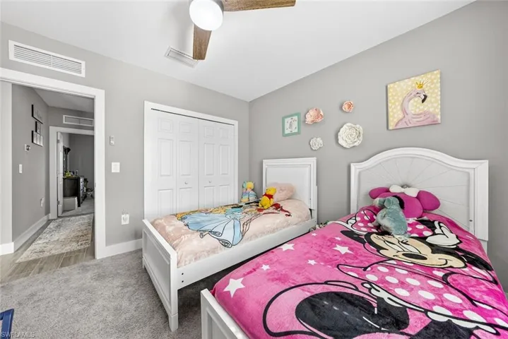 Bedroom featuring a closet, a ceiling fan, and light carpet