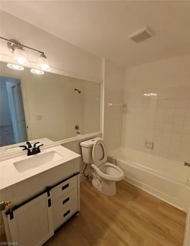 Full bathroom with bathtub / shower combination, light wood-style flooring, and vanity