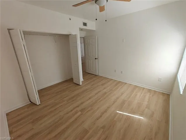Unfurnished bedroom featuring a closet, light wood-type flooring, and a ceiling fan