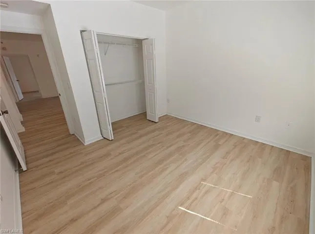Unfurnished bedroom with a closet and light wood finished floors