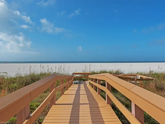 View of home's community with a water view and a view of the beach