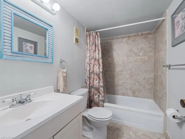 Full bath featuring vanity, visible vents, toilet, tile patterned floors, and shower / bath combo with shower curtain