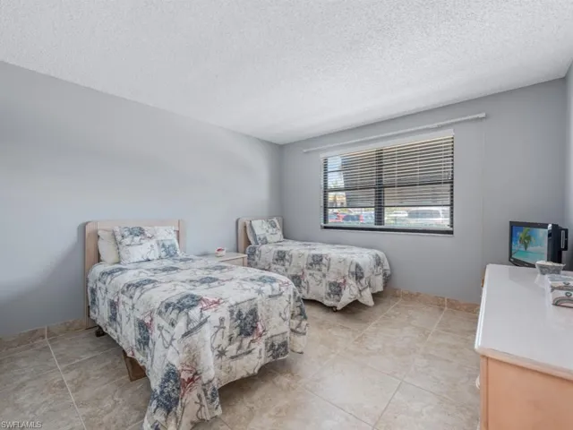Bedroom with light tile patterned floors and a textured ceiling