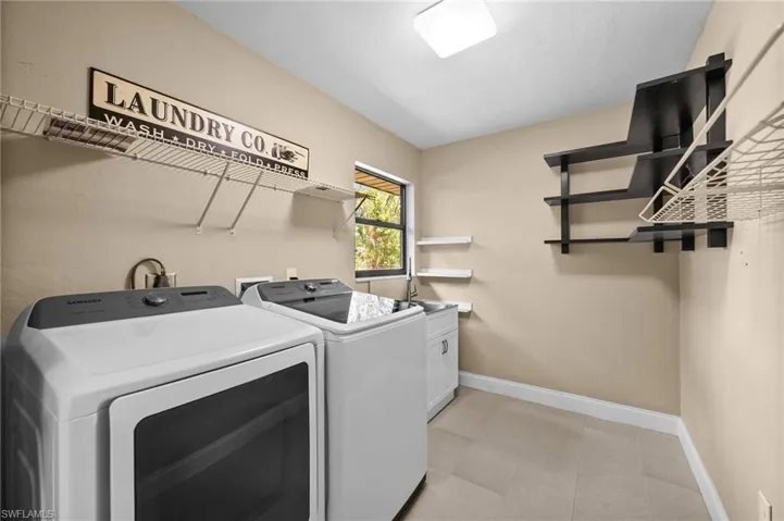 Laundry Room with laundry sink & ample shelving space for storage.