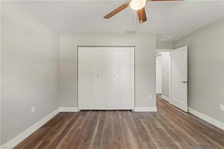 Unfurnished bedroom with dark wood finished floors, a closet, ceiling fan, and a textured ceiling