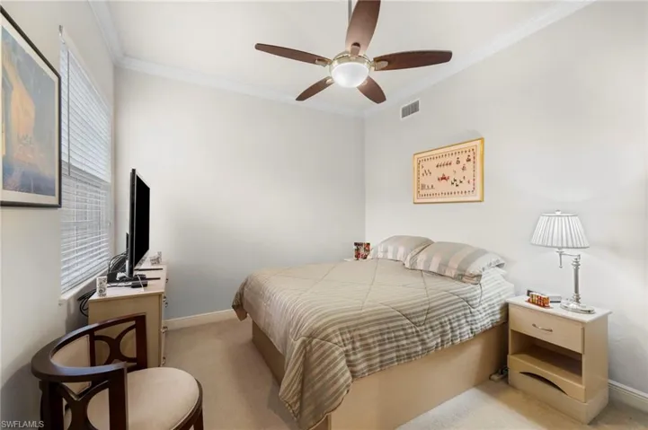 Carpeted bedroom with crown molding and ceiling fan