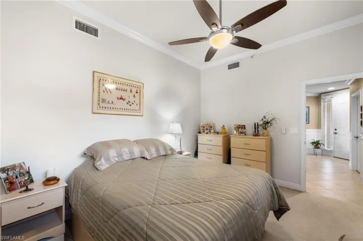 Carpeted bedroom with crown molding and ceiling fan