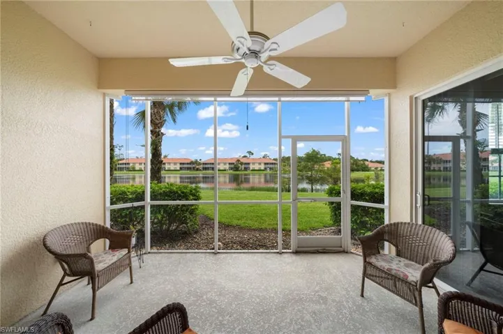 Sunroom / solarium with a healthy amount of sunlight, ceiling fan, and a water view