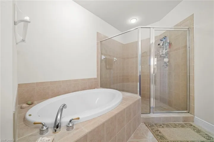 Bathroom with tile flooring and separate shower and tub