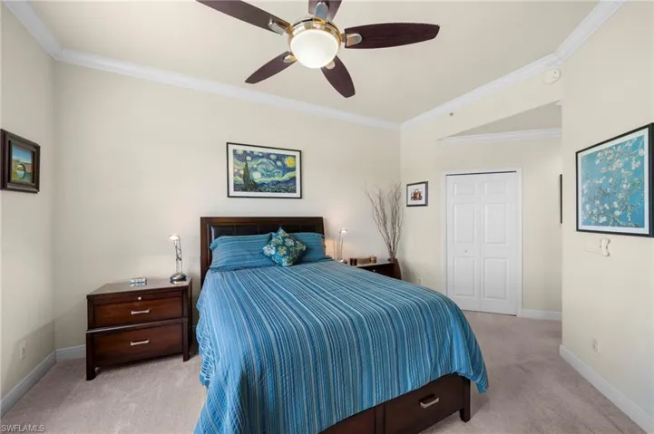 Bedroom featuring light colored carpet, ornamental molding, ceiling fan, and a closet