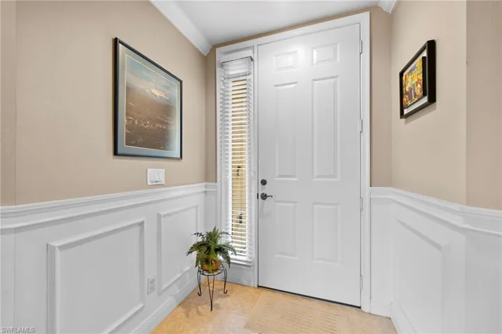 Tiled foyer with crown molding