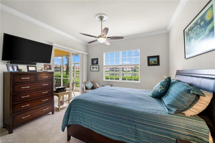 Carpeted bedroom with ornamental molding and ceiling fan