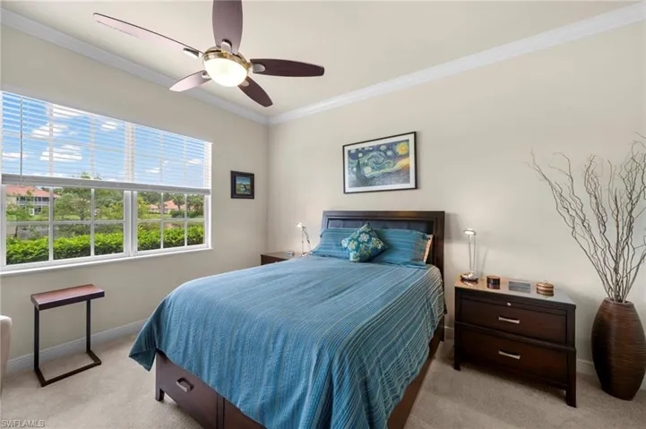 Carpeted bedroom with ornamental molding and ceiling fan
