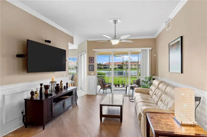 Living room with ornamental molding, ceiling fan, and hardwood / wood-style floors