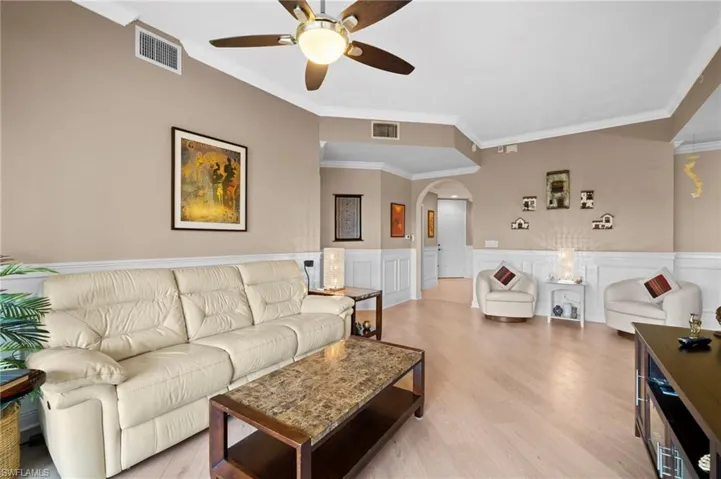 Living room with hardwood / wood-style floors, ornamental molding, and ceiling fan