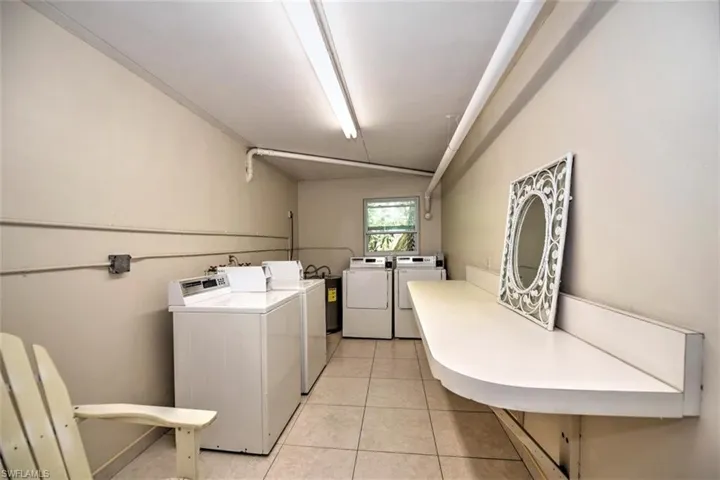 Laundry area with separate washer and dryer and light tile patterned floors