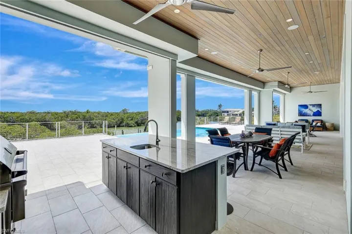 View of patio / terrace with ceiling fan, a sink, and outdoor dining area