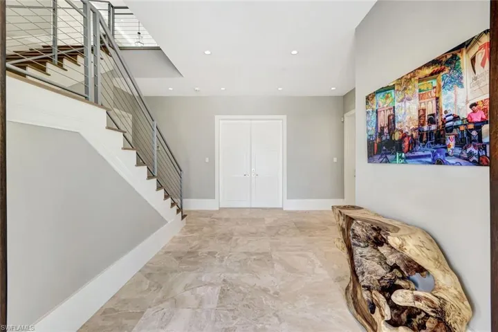 Foyer entrance featuring stairs, recessed lighting, and baseboards