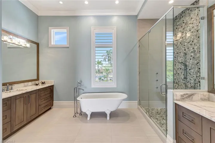 Master Bathroom with a stall shower, vanity, a freestanding bath, tile patterned floors, and baseboards