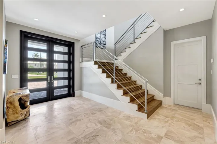 Entrance foyer featuring french doors, stairway, marble finish floors, baseboards, and recessed lighting