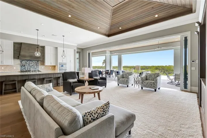 Living room with wooden ceiling, crown molding, a tray ceiling, recessed lighting, and light wood finished floors