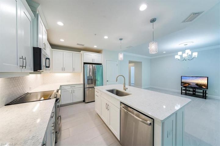 Beautiful kitchen, bright and open, granite counters and attractive backspalsh, new stainless appliances and pantry next to fridge.