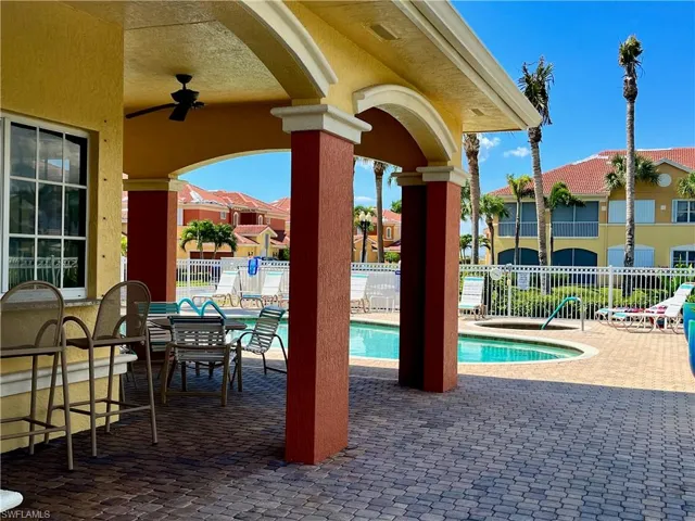Community pool with a patio area and a ceiling fan