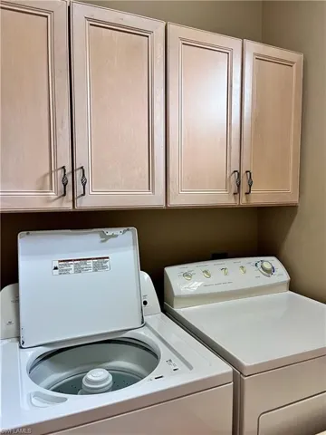 Washroom featuring washing machine and dryer and cabinet space