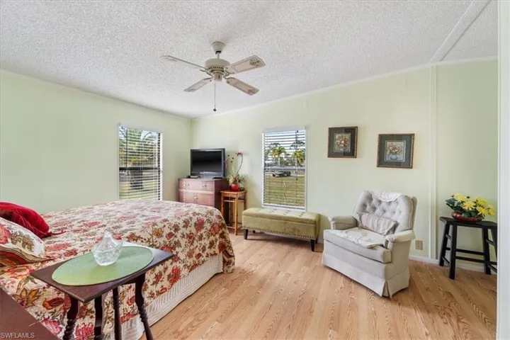 Bedroom featuring crown molding, light hardwood / wood-style floors, and multiple windows