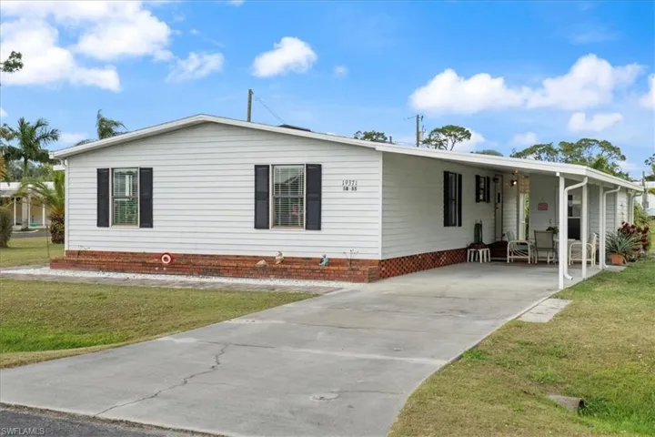 View of front of home with a carport and a front lawn