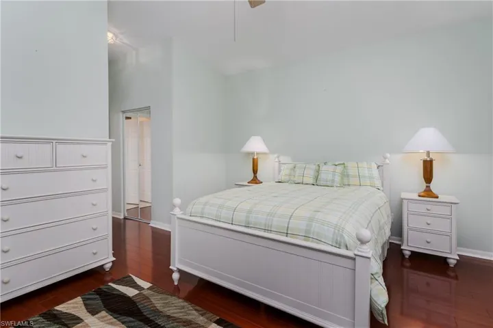 Vaulted ceiling, dark wood-finish flooring, and mirrored closet doors