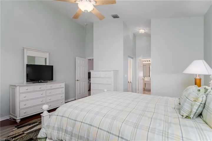 Vaulted ceilings, wood-finish flooring, and a ceiling fan with integrated lighting