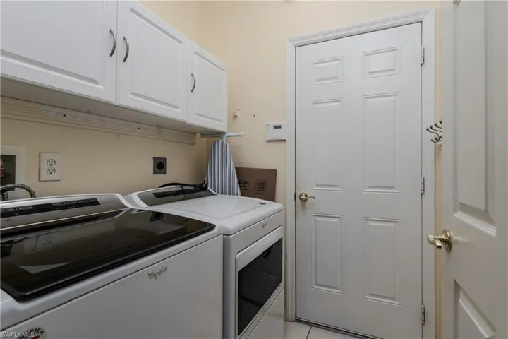 White shaker-style cabinetry with brushed nickel hardware, light-toned wall paint, and a paneled interior door with a brass-finish knob