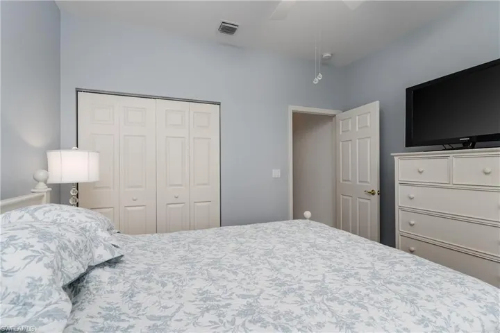 Vaulted ceiling with a flush-mount light fixture, painted interior door, and bi-fold closet doors