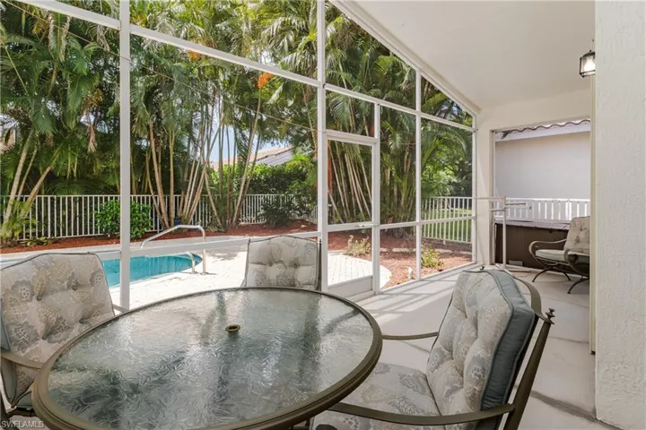 Screened-in patio with concrete flooring, integrated lighting, and a white railing