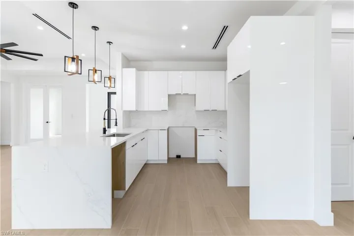 Kitchen featuring light stone countertops, wood-look tile, modern cabinets, and a peninsula