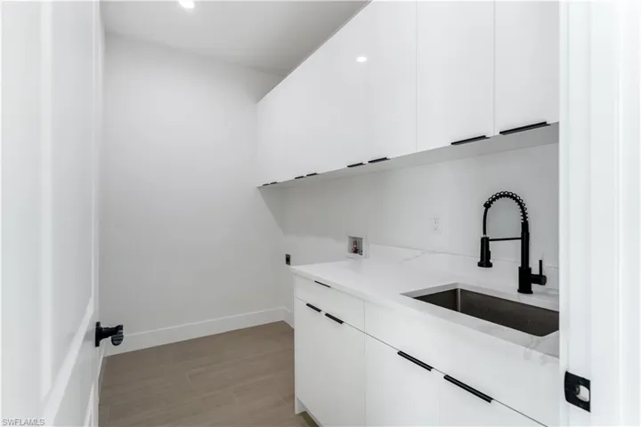 Laundry area with cabinet space, wood look tile, washer hookup, recessed lighting, and hookup for an electric dryer