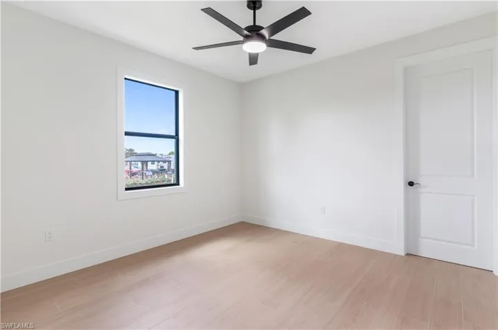 Bedroom with wood-look tile and a ceiling fan