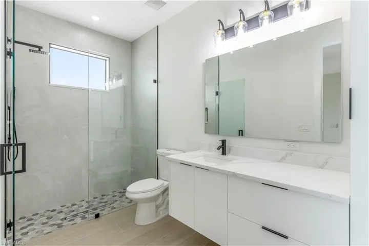 Bathroom featuring vanity, a stall shower, and wood-look tile.